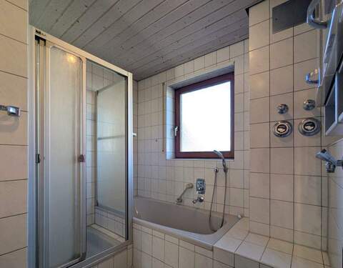 Badezimmer ausgestattet mit Badewanne und Duschkabine - 