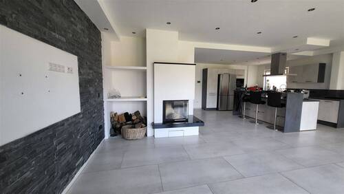  Wohn- und Eßbereich mit offener Küche und Kamin - 