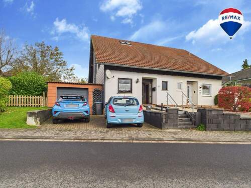 RE/MAX Immobilien DeLux Einfamilienhaus Niederlosheim Außenansicht - Charmante Doppelhaushälfte mit Wintergarten und Gartenparadies