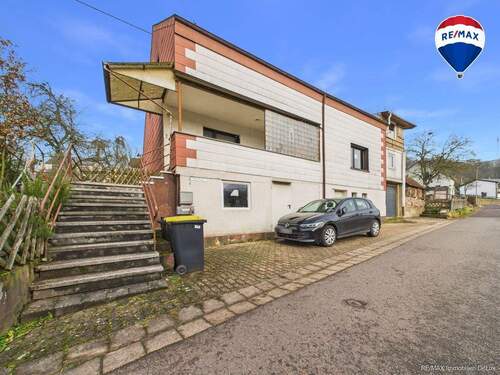 REMAX Immobilien DeLux Einfamilienhaus Frontansicht Schmeltz Mark Borowicz - Wohnhaus in Schmelz-Limbach mit vielseitigen Nutzungsmöglichkeiten