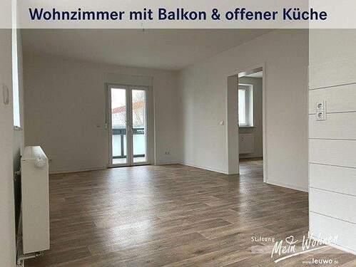 Wohnzimmer mit offener Küche und Balkon - 