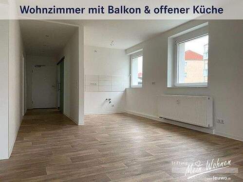 Wohnzimmer mit offener Küche und Balkon - 