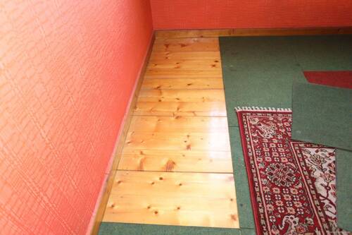 Dielenboden unter den Teppichfliesen im Dachgeschoss - 