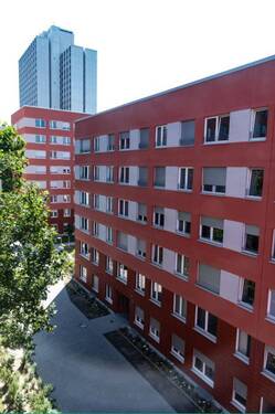 Blick auf die Vorderansicht der Mehrfamilienhäuser mit roter Fassade - 3-Zimmerwohnung im Lyoner-Quartier sucht neue Bewohner