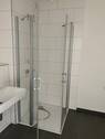 Beispiel eines Badezimmers mit Dusche, weißem Wandwaschbecken und Glas-Duschabtrennung mit weißen Wandfliesen auf anthrazitfarbenen Fliesenboden - Etagenwohnung mit 105,50 m&sup2; in Frankfurt am Main zur Miete