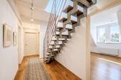 Offene Raumgestaltung mit markanter Stahl-Holz-Treppe - 