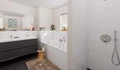 Modern gefliestes Tageslichtbad mit Badewanne im O - 