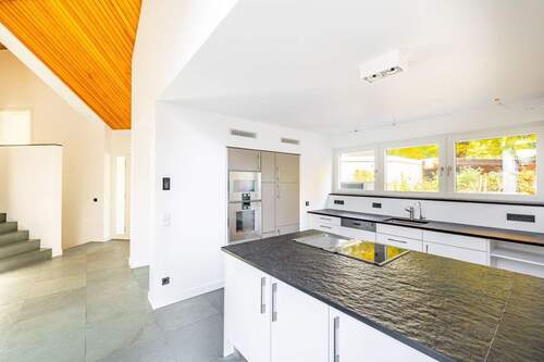 Die offene Küche mit edlem Küchenblock und Naturst - 