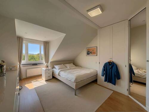 Lichtdurchflutetes Dachgeschoss-Schlafzimmer mit Panorama-Ausblick und intelligenter Raumnutzung - 