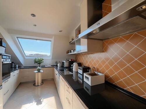 Lichtdurchflutete Dachgeschoss-Küche mit Panorama-Dachfenster und durchdachter Raumaufteilung - 