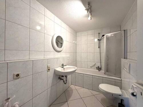 Badezimmer mit Badewanne und Waschmaschinenanschluss - 