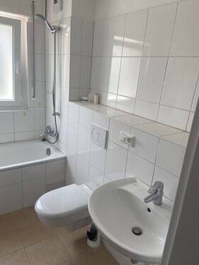Bad mit Badewanne, WC, Waschbecken, weiße Fliesen - 4 Zimmer Etagenwohnung in Darmstadt