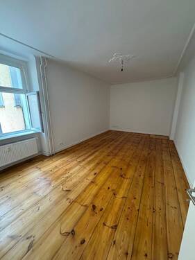 Leeres Zimmer mit Holzboden - Charmante 1-Zimmer-Wohnung in Berlin - Sonnenallee
