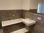 Referenzbild Bad mit grauen Fliesen Wanne Waschtisch.JPG - 2 Zimmer Etagenwohnung in Leipzig