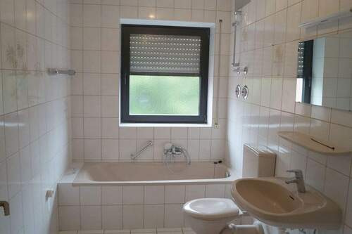 Badezimmer mit Fenster und Wanne - 
