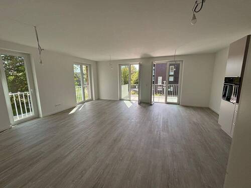 Helles Wohnzimmer mit Zugang zum Balkon - Helle 3-Zimmer-Wohnung in Schleswig – Erstbezug mit Einbauküche