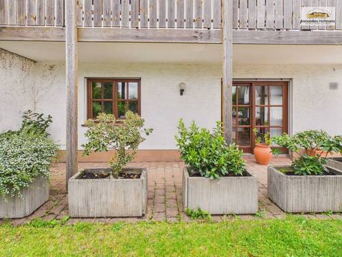 Gepflegter Außenbereich mit Terrasse und Zugang zur Wohnung - 