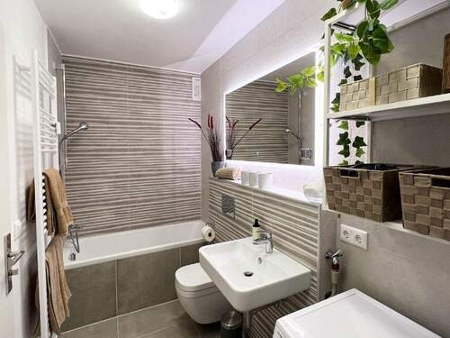 Badezimmer mit Duschwanne, Dusche sowie WC - 