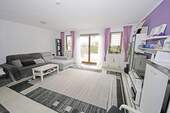 Wohnzimmer im EG mit Zugang zur Terrasse - 