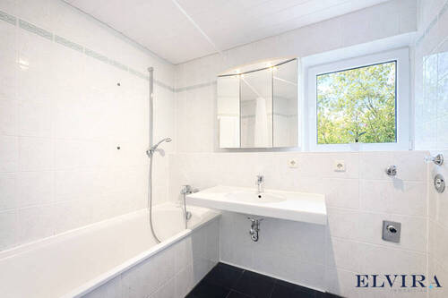 Badezimmer mit Badewanne und Waschmaschinenanschluss - 