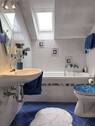 Gefliestes Badezimmer mit Dachfenster - 