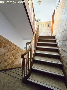 Komfortabel gestaltet: Großzügige Holztreppe mit rutschfesten Einlagen verbindet Etagen sicher und elegant - 