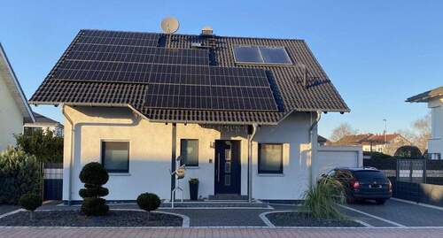 Ansicht von vorne + PV-Anlage - Modernes, freistehendes Einfamilienhaus in naturnaher Lage von Bürstadt - ideal für Familien