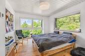 Schlafzimmer mit angrenzendem Ankleidezimmer und Weitblick im ersten Obergeschoss - 