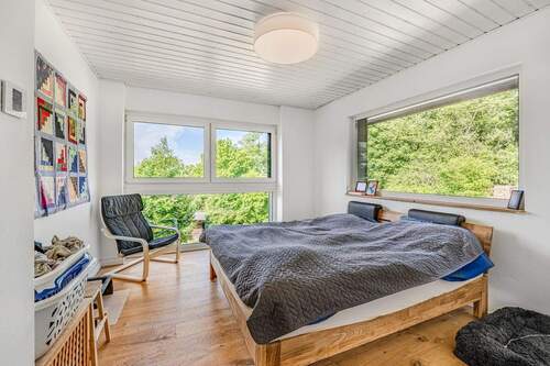 Schlafzimmer mit angrenzendem Ankleidezimmer und Weitblick im ersten Obergeschoss - 