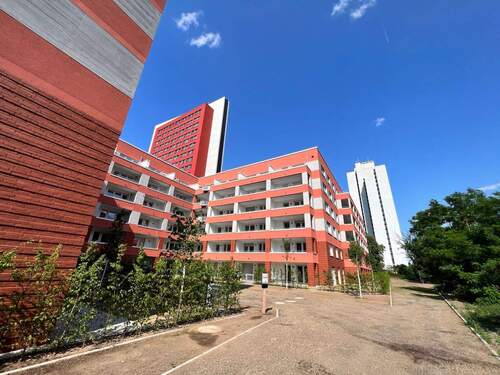 Rückansicht der Mehrfamilienhäuser mit Loggien, umgeben von grünen Sträuchern - Etagenwohnung mit 57,60 m² in Frankfurt am Main zur Miete