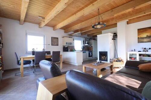 Wohnzimmer mit Kamin-Speicherofen - 3 Zimmer Mehrfamilienhaus, Wohnhaus zum Kaufen in Rieder