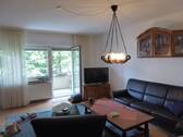 das Wohnzimmer mit Ausgang zum Balkon - 