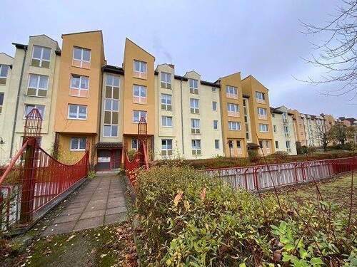 Gebäudeansicht Carl-Bantzer-Straße 34 - 36a, Fassade in Orangetönen, verwinkelete Dachflächen, die Garagen befinden sich vor dem Haus auf einer unteren Ebene - 3 Zimmer Etagenwohnung in Baunatal