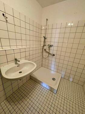 Badezimmer mit weißen Fliesen und Dusche - 2 Zimmer Etagenwohnung zur Miete in Baunatal