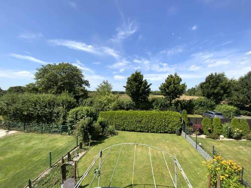 hinter dem Haus erstrecken sich weitläufige Wiesen und Felder - 