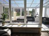 Wohnzimmer mit Terrassentür zum Wintergarten - 