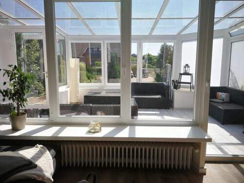 Wohnzimmer mit Terrassentür zum Wintergarten - 