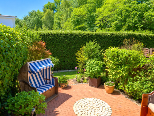 Sonniger Gartenpatio mit Strandkorb - 