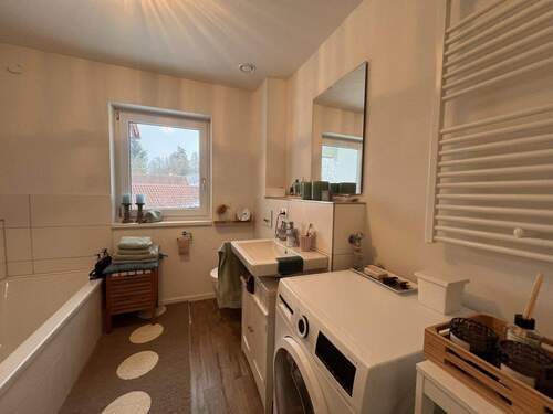 Praktisches Tageslicht-Badezimmer mit integrierter Waschmaschinenstation und Handtuchablage - 