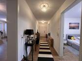 Lichtdurchfluteter Wohnungsflur mit eleganter Raumaufteilung und stilvollem Läufer - 