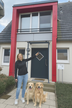 deichhaus foto frau zeigt auf haus mit hunden.png - 