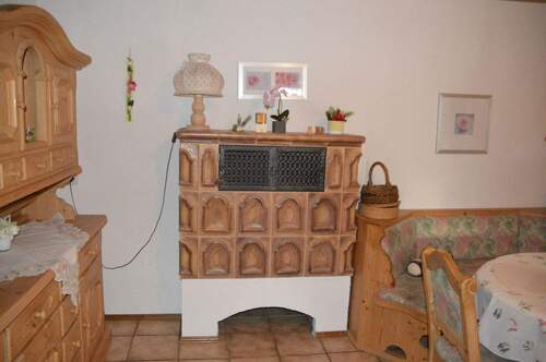 Kachelofen und Essecke und Zugang zum Balkon - 