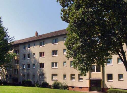 Gebäude Vorderseite des mehrstöckigen Wohnhauses umgeben von Grünanlagen mit Bäumen - 