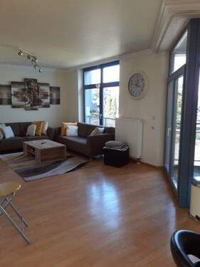 Wohnraum mit Fensterfront zum Garten - Charmante, lichtdurchflutete 2-Zimmer-Wohnung mit überdachtem Balkon in Hoengen!