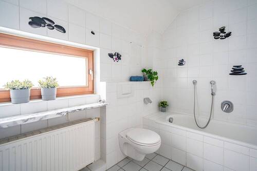 Das Badezimmer besitzt eine Wanne. - 