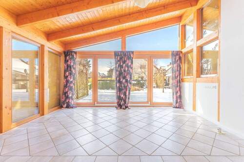 Wintergarten mit Ausgang zur Terrasse und dem Gart - 
