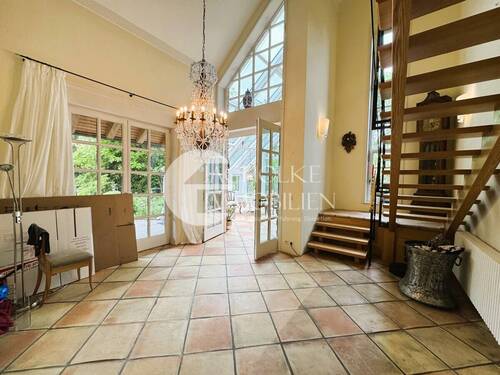 Elegantes Esszimmer mit Treppe und Wintergartenzugang - 