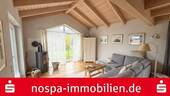 Wohnbereich mit Kaminofen - Wohntraum in Küstennähe: Moderner Vierck-Holzhaus-Bungalow mit Top-Ausstattung
