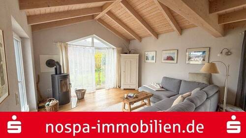 Wohnbereich mit Kaminofen - Wohntraum in Küstennähe: Moderner Vierck-Holzhaus-Bungalow mit Top-Ausstattung