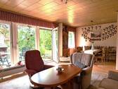 Das helle Wohn-Esszimmer mit bodentiefen Fenstern und Terrasssenausgang bildet das Herzstück des Hauses - 